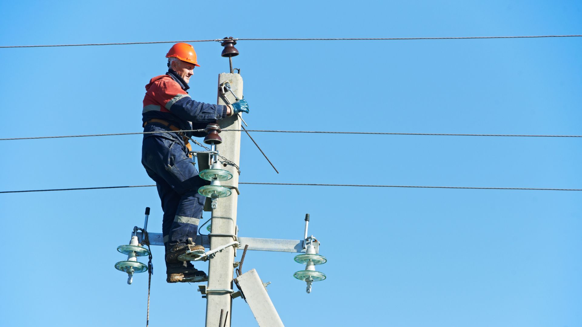 utilities company repairing a power pole
